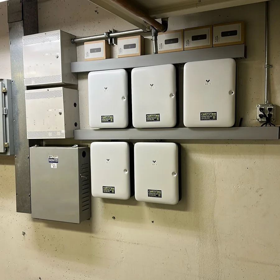 Row of Fortified Technologies access control panels and power supplies mounted in a building electrical room