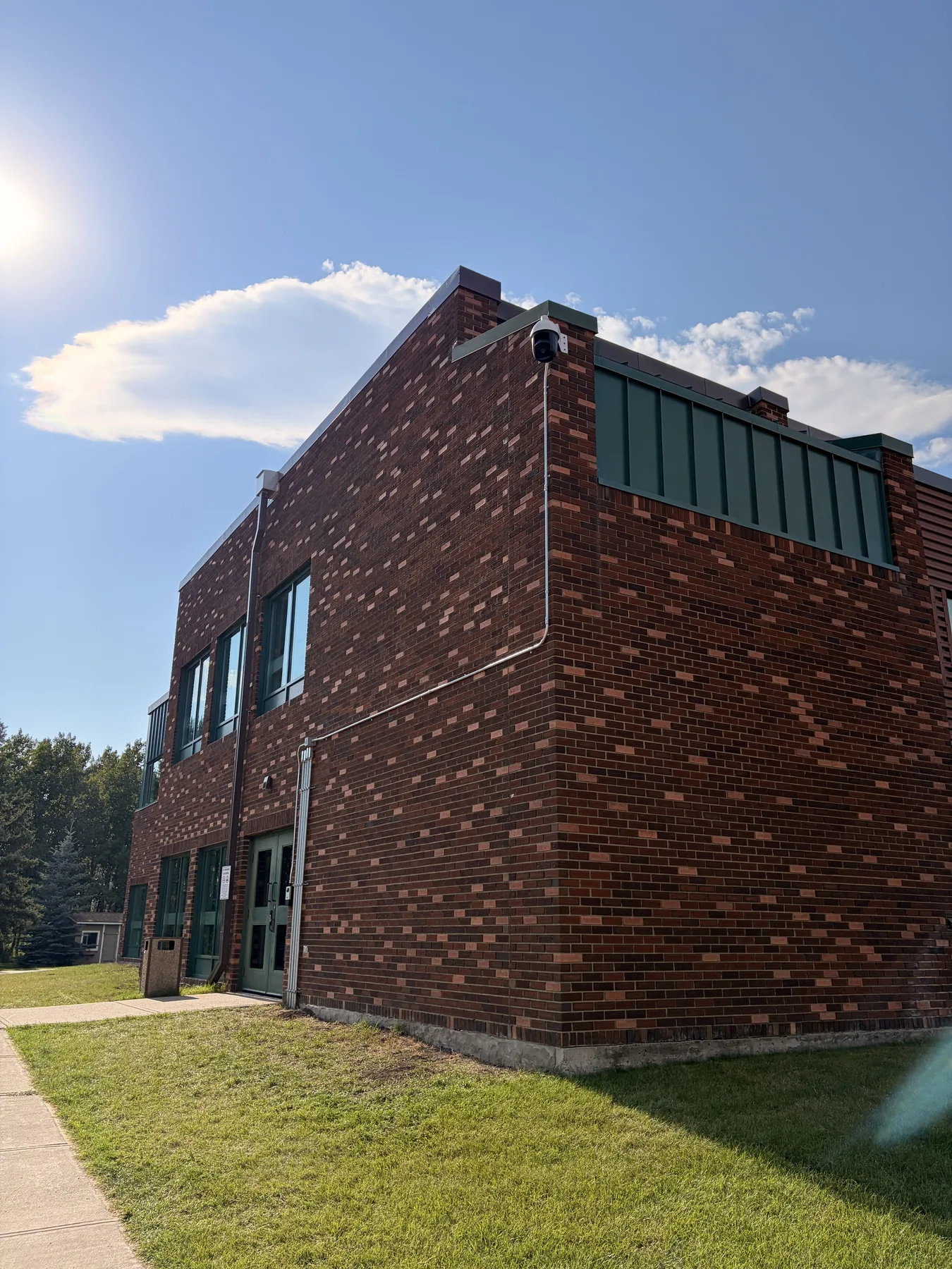 Exterior security camera mounted on the corner of a brick commercial building